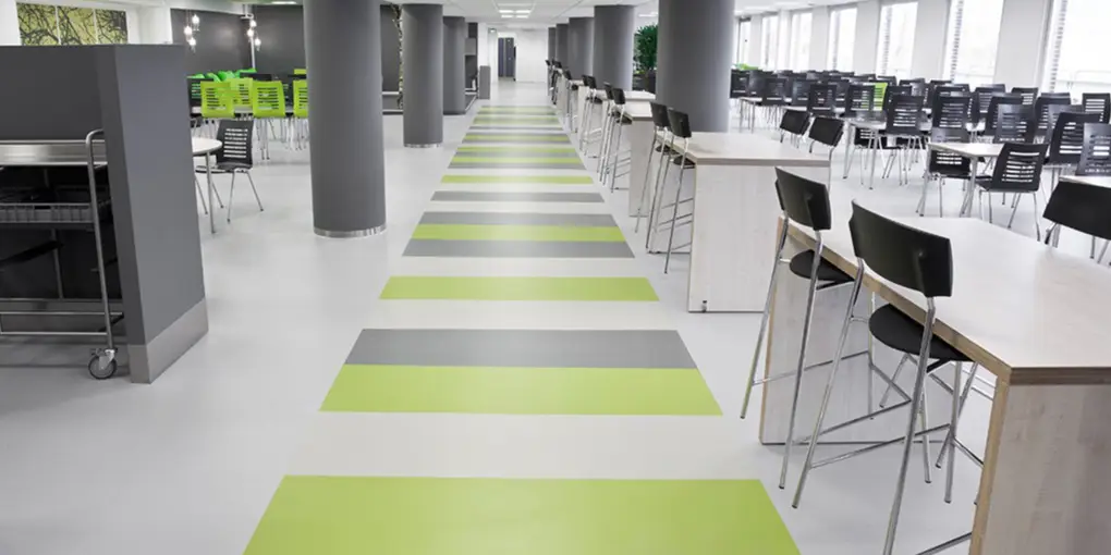 Großer Speisesaal oder Büroraum mit weiß-grünem Boden und Tischen – Link zu den Referenzen
